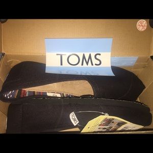 Black on black, slip-on Toms.